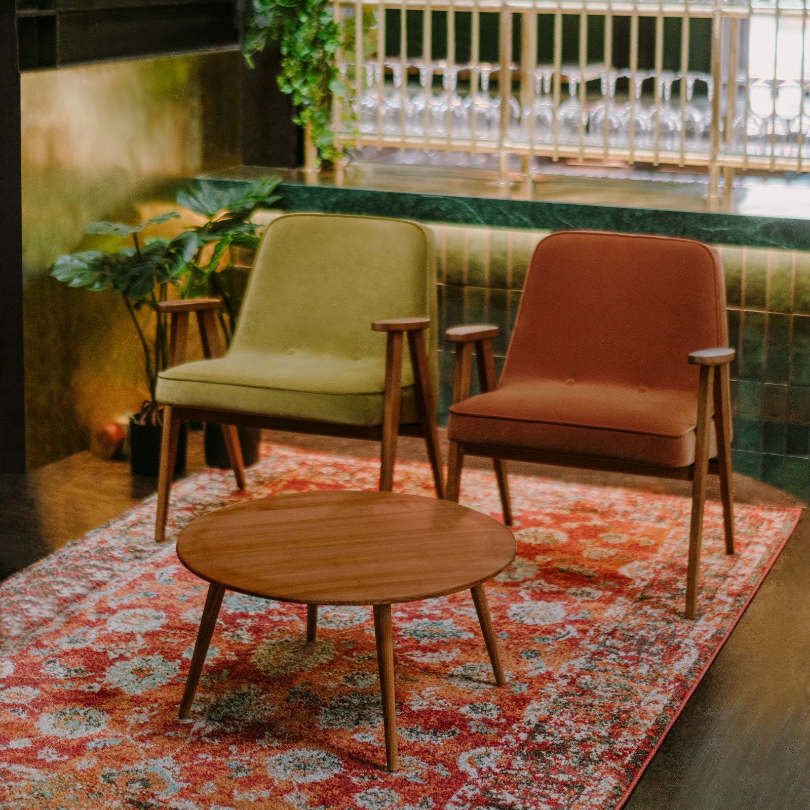 Kamer met een rood vloerkleed met twee stoelen en een tafeltje