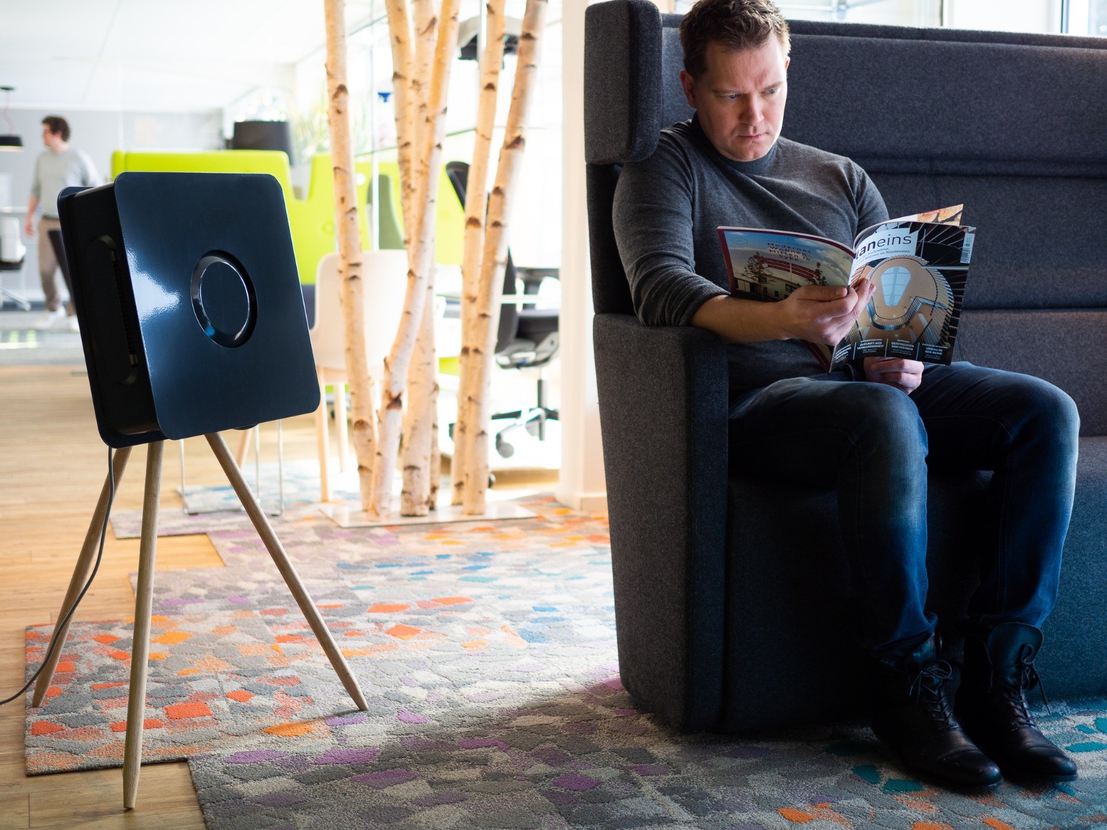 Kamer met grijze bank met persoon die aan het lezen is en een Urban-Line apparaat van BKE Health