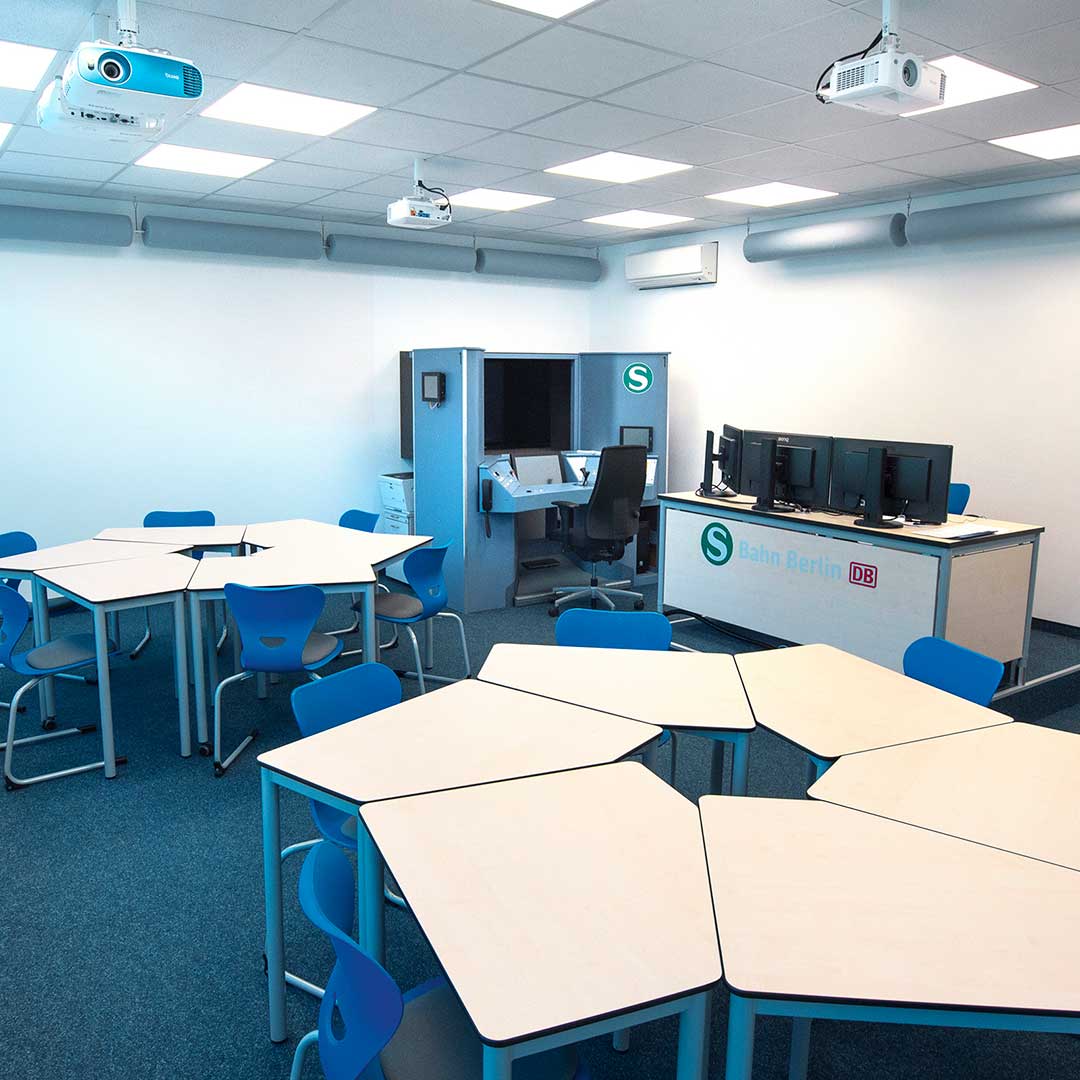 Tafel met blauwe stoelen in een klaslokaal