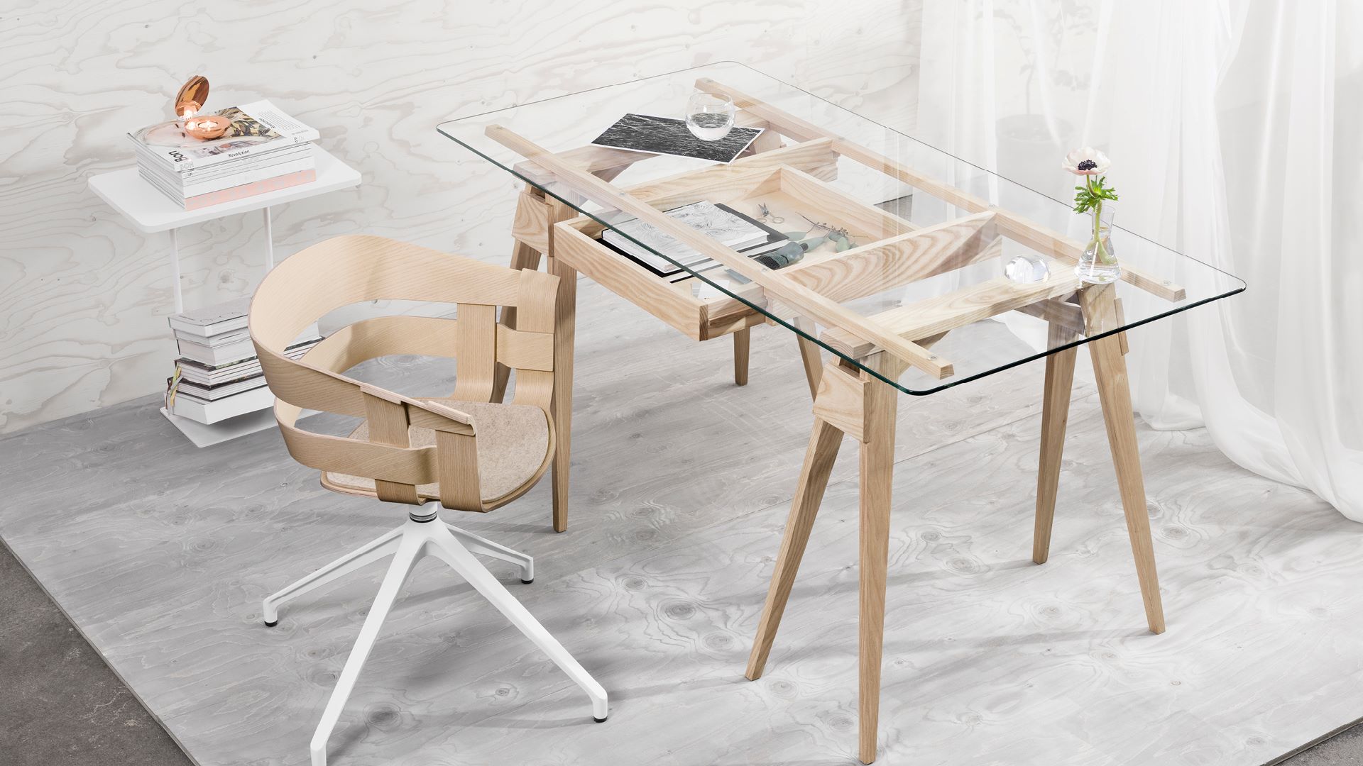 Een werkplek/bureau van hout met glas en een stoel