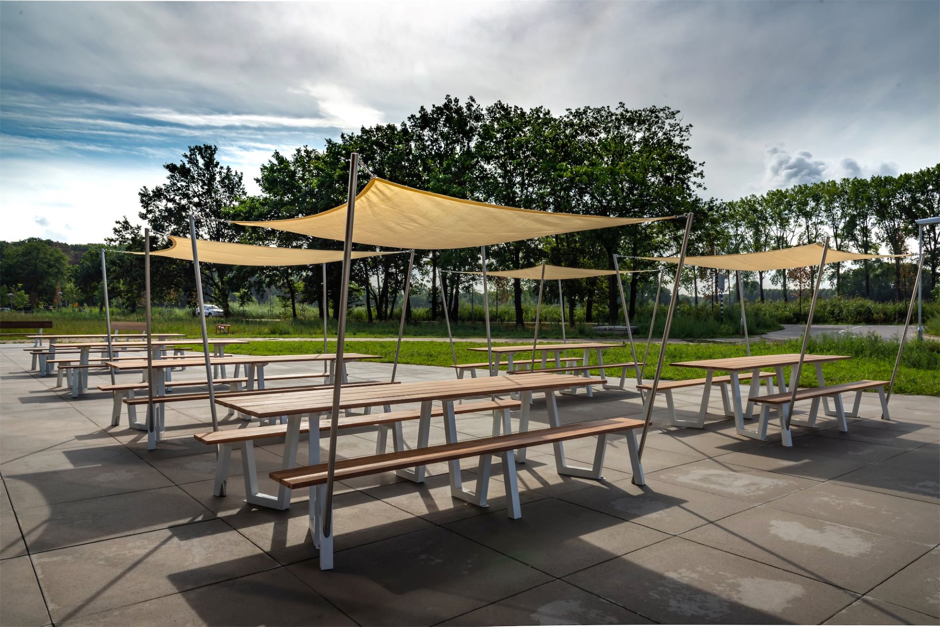 Open ruimte met picknicktafels met zonnescherm
