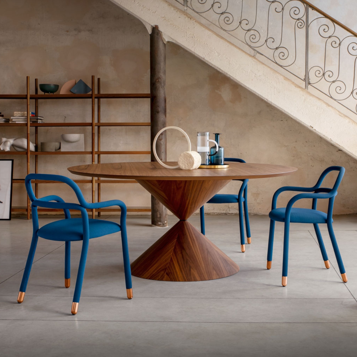 Een grote ronde tafel met blauwe stoelen van Midj