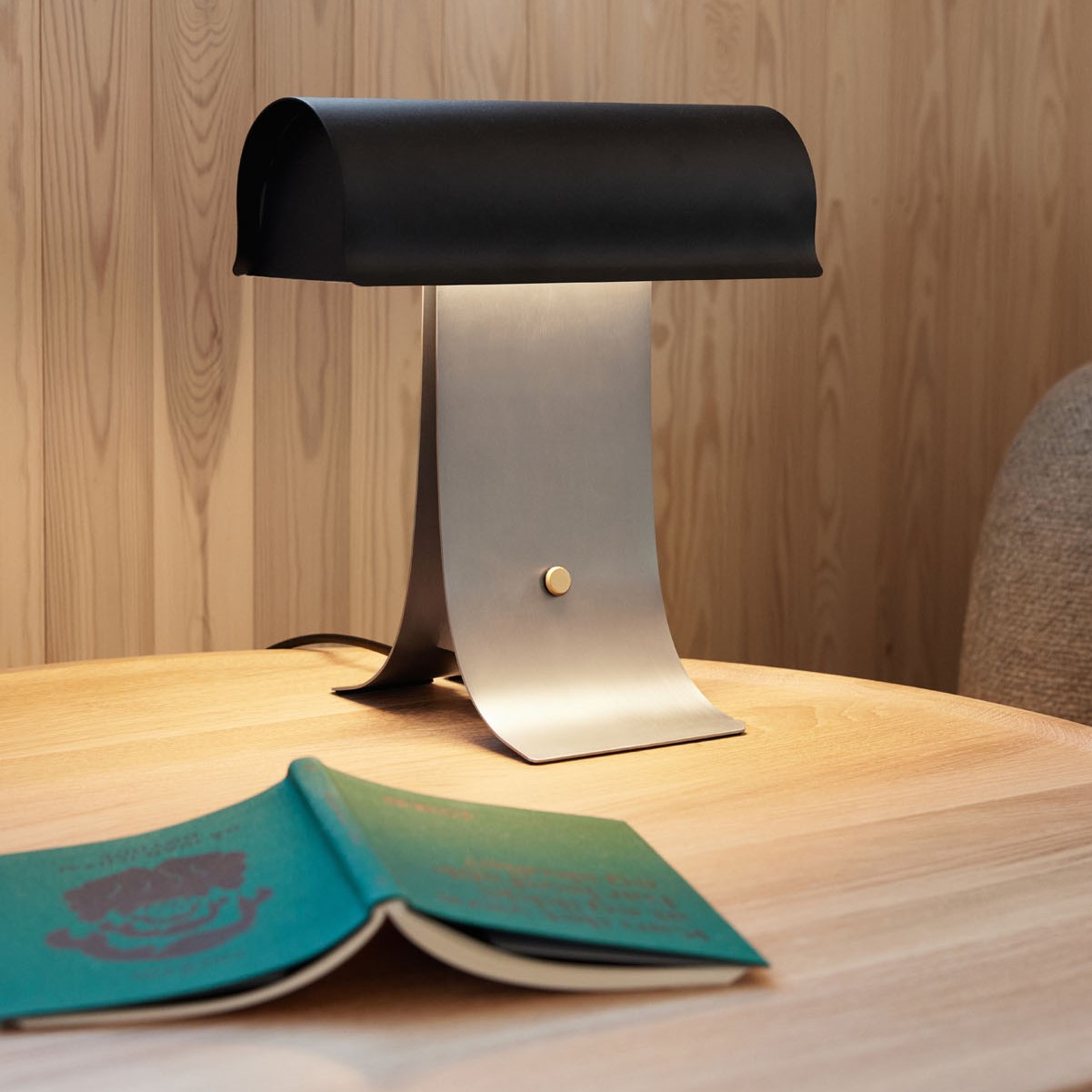 Bureau van hout met een close-up van een stalen zwarte lamp gemaakt door Northern,