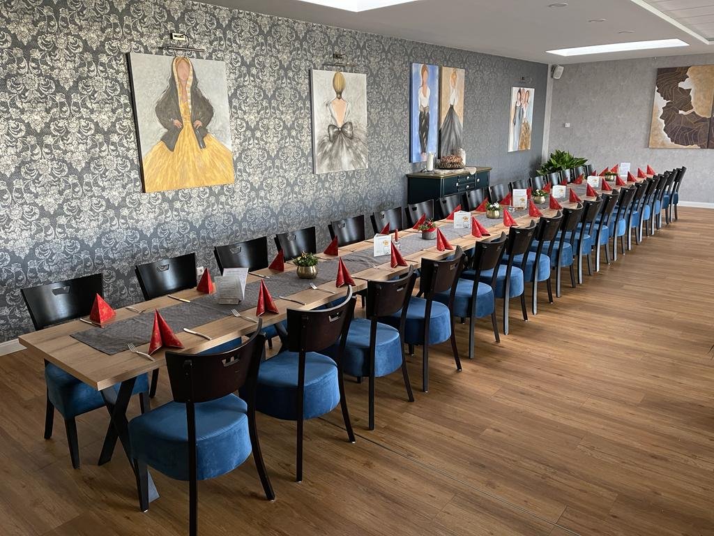 Zijaanzicht van een hele lange tafel met stoelen van ERDIES Sitzmöbel