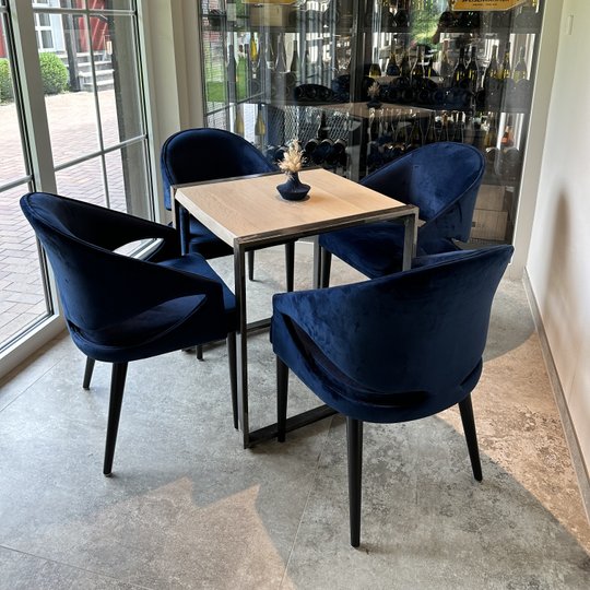 Ruimte met tafel en vier blauwe gestoffeerde stoffen.