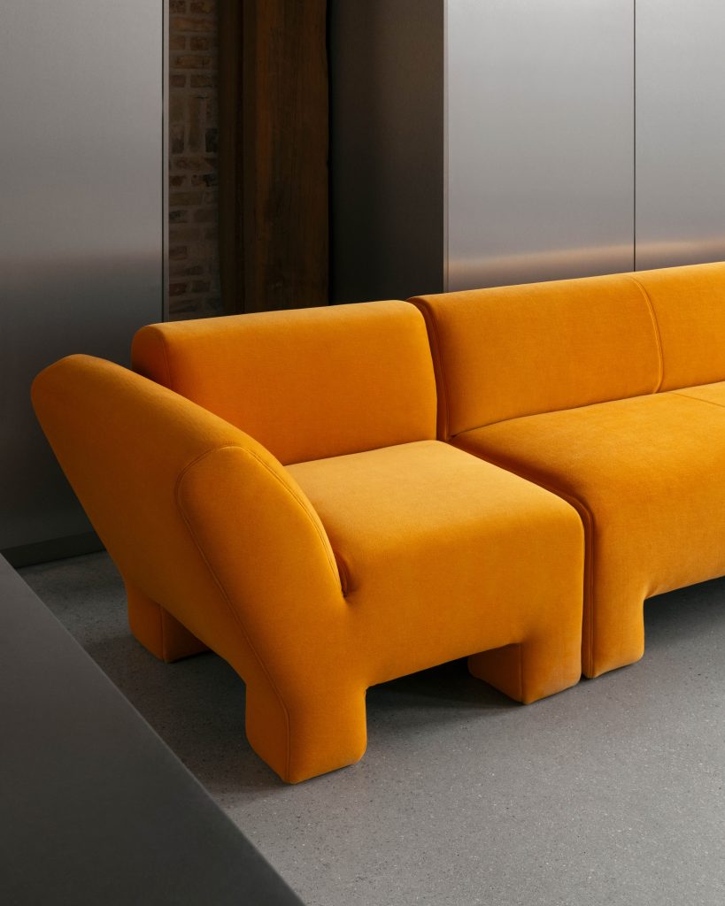 Grijze ruimte met een oranje bank
