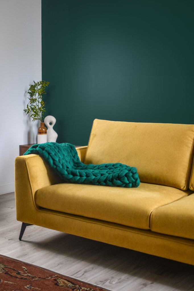 Ruimte met groene wand en gele bank van scandicsofa