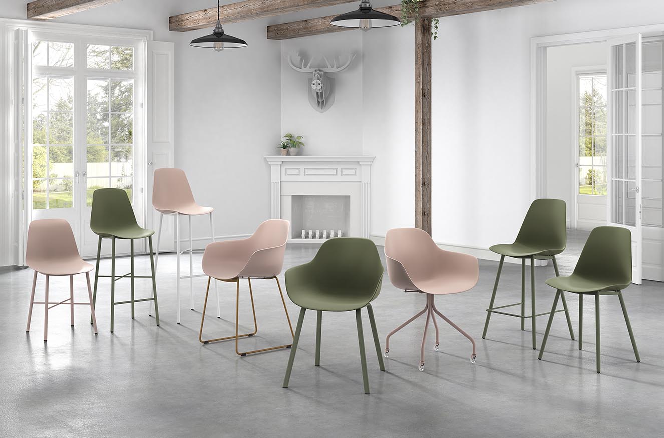 Grote witte ruimte met openhaard, lampen en stoelen in groen en roze van Perfecta.