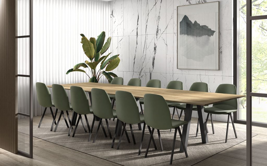 Grote witte ruimte met zwarte stalen deuren en lange tafel met groene stoelen.