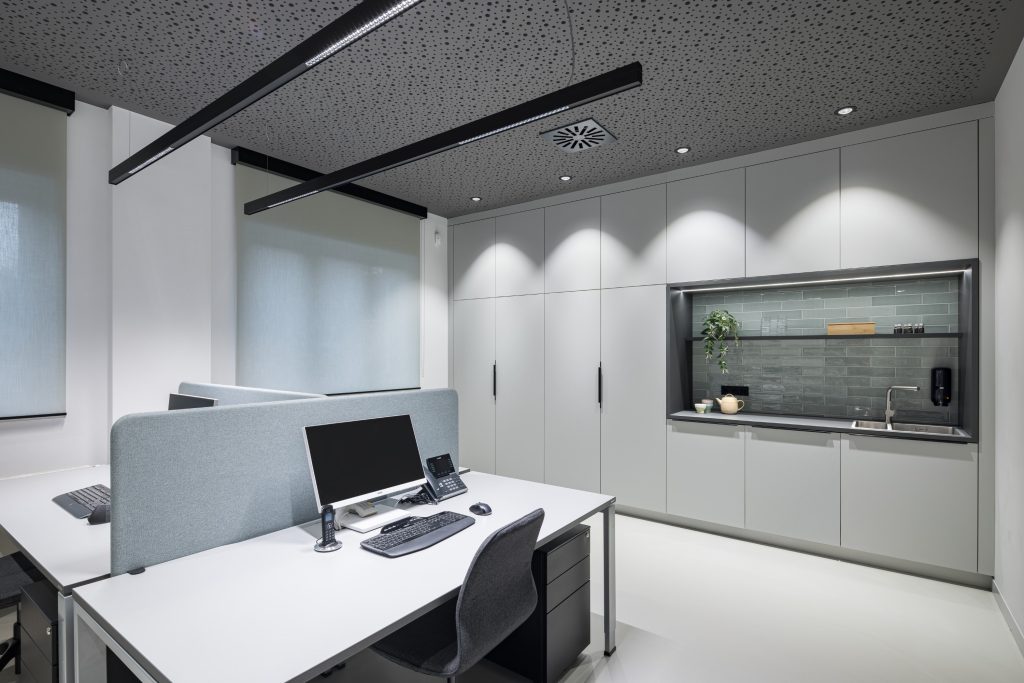 Grijze ruimte met twee witte bureau's met laptops