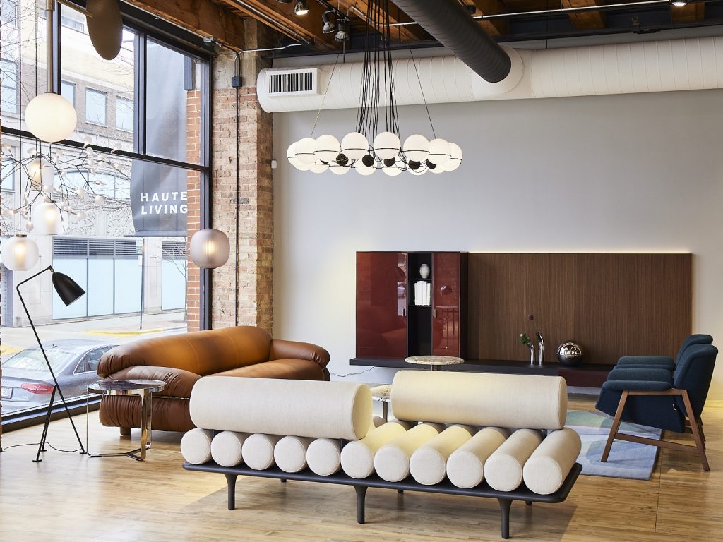 Showroom ruimte van Haute Living met witte bank, lamp en kast.