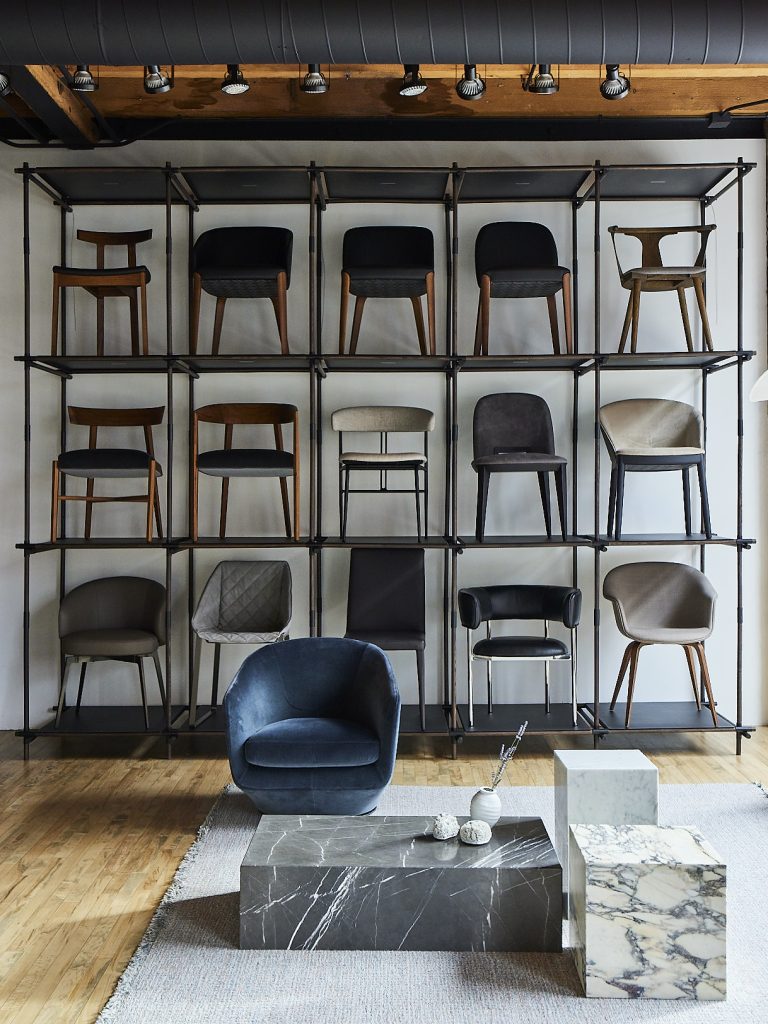 Stellingkast met verschillende stoelen in de showroom van Haute Living