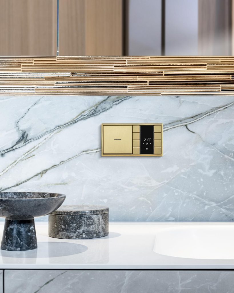 Badkamer met wit marmer en goude kraan.