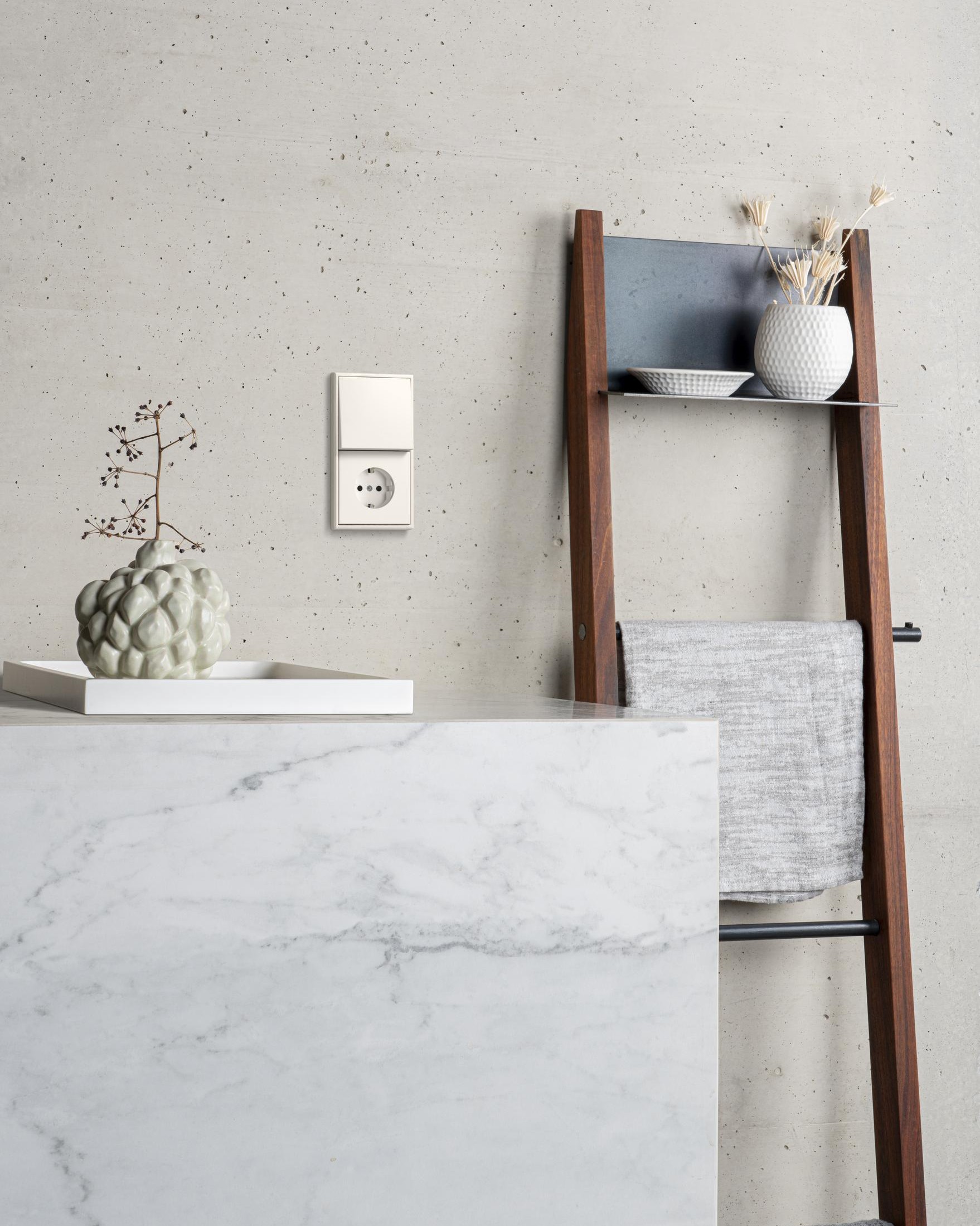 Witte badkamer met ladder voor handdoeken en lichtschakelaar van Albrecht JUNG.