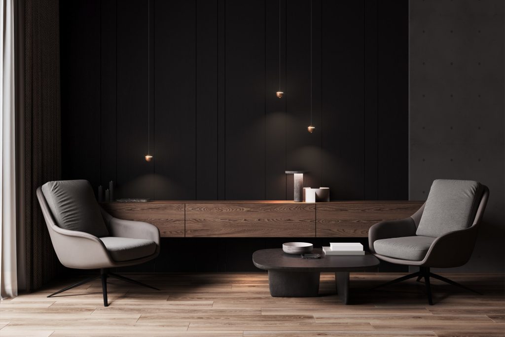 Zwarte hotelkamer met grijze stoelen.
