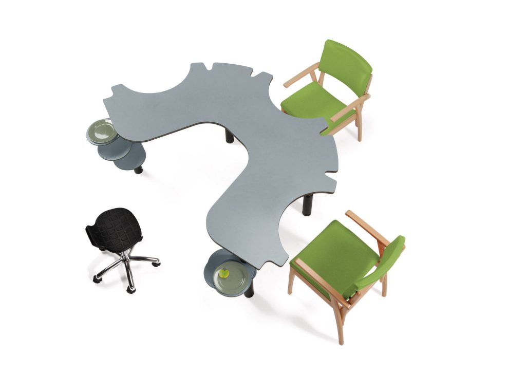 Ruimte met ronde tafel en groene stoelen en zwarte kruk.