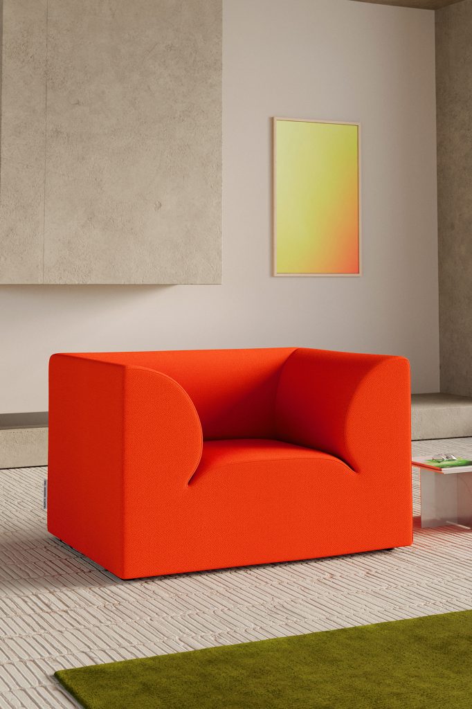 Grijze ruimte met fel oranje stoel en witte vloerkleed.