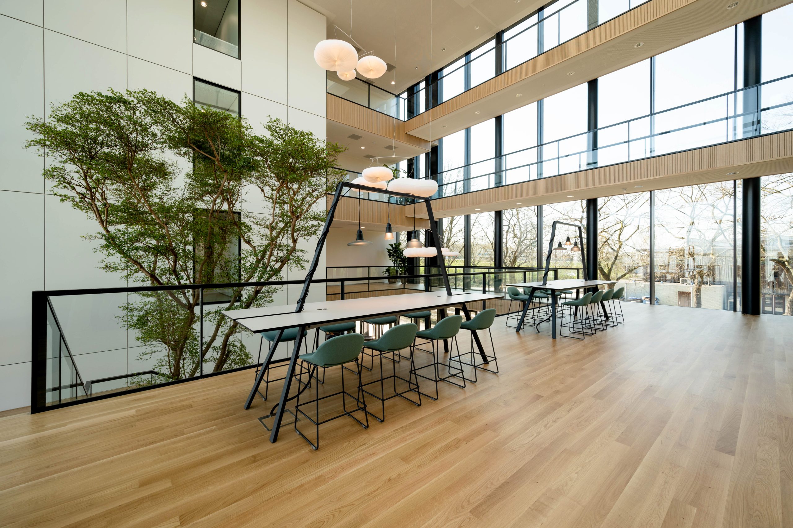 Overloopruimte binnen een modern kantoorgebouw met tafels en stoelen van meubelfabrikant Lande.