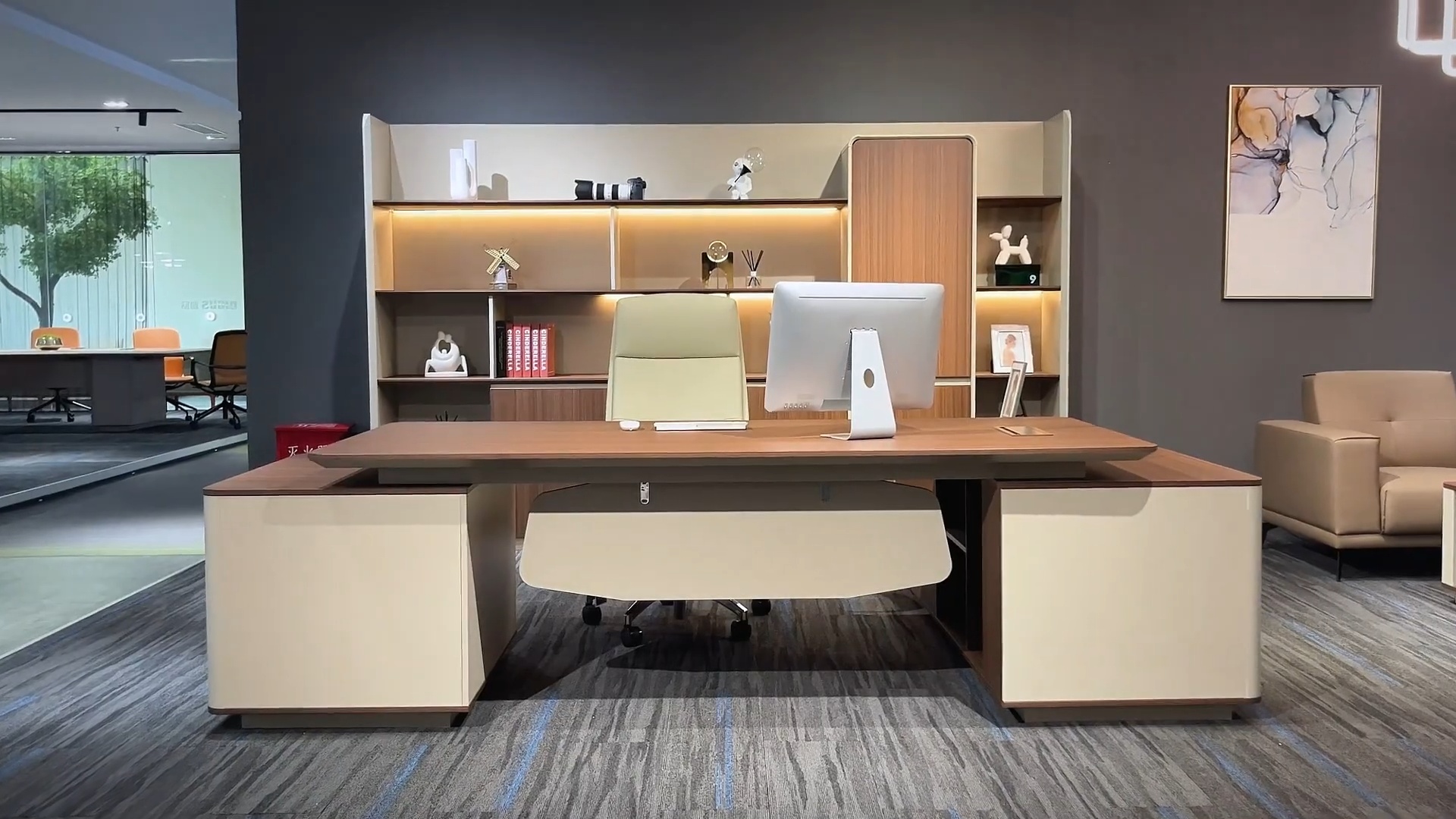 Vooraanzicht van een groot bureau met macbook, stoel en grote kast erachter.