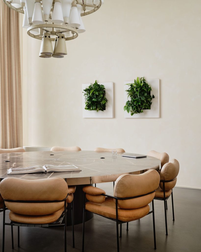Eetkamer met ronde tafel, stoelen en twee plantenframes van Mobilane.