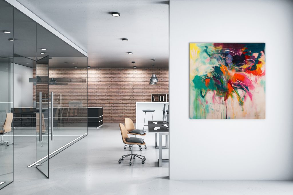 Witte kantoorruimte met kantoorspullen, glazen ruimte en kunstwerk.