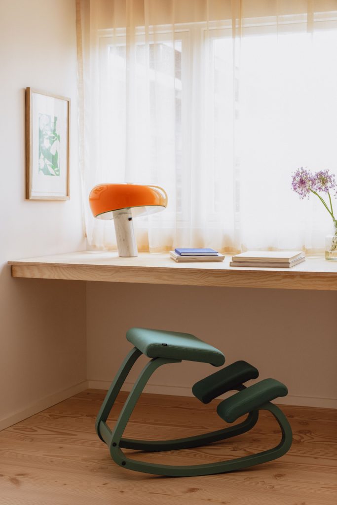 Thuis kantoor met een groene kruk en houten tafel