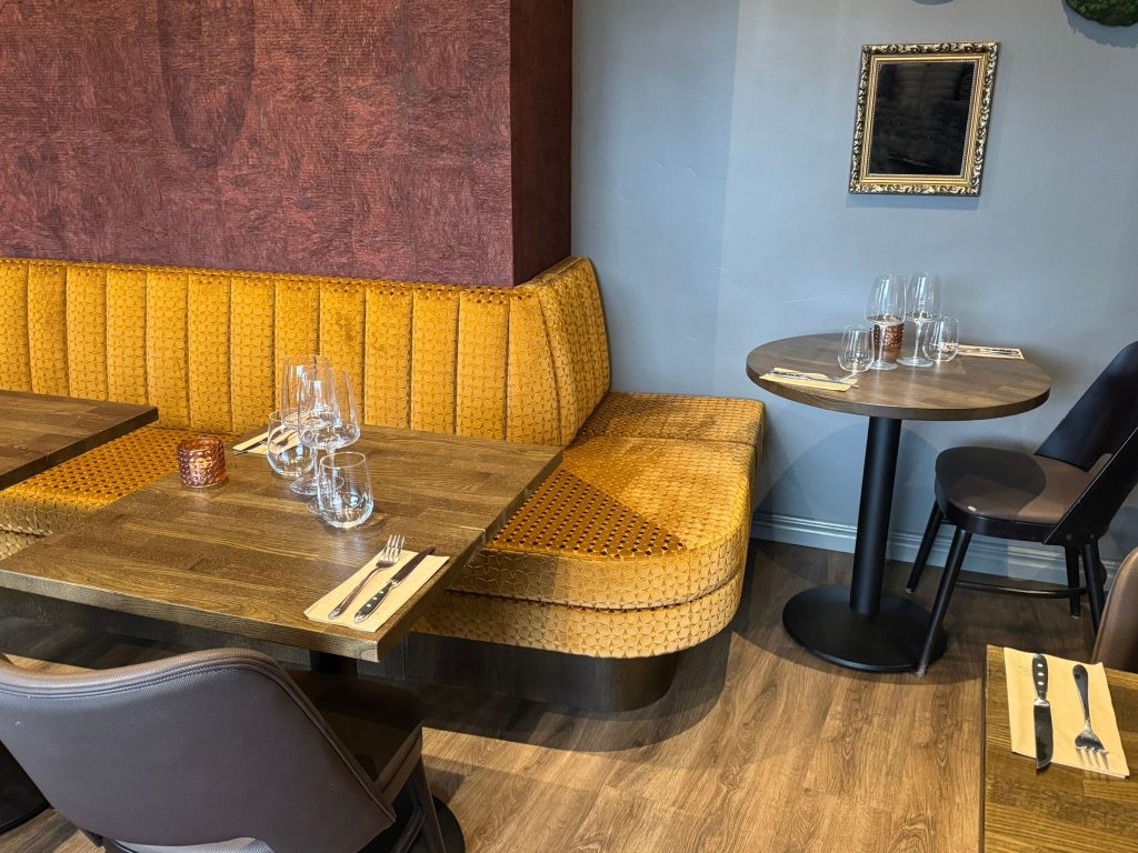 Vooraanzicht van een zachte fluwelen gele bank in een horecagelegenheid