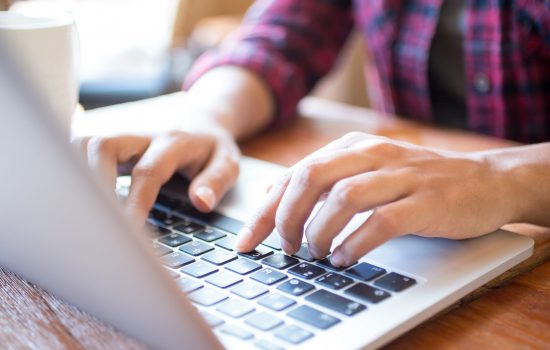 close-up-female-student-typing-laptop-table-min